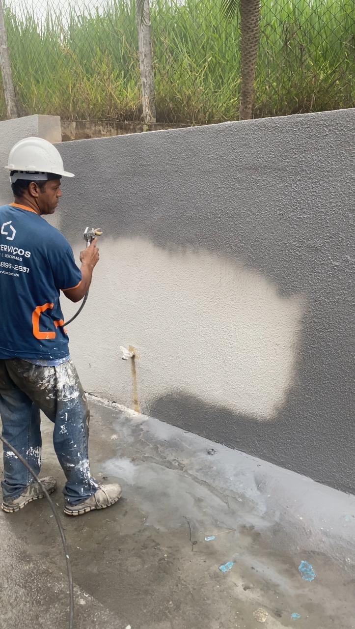 Profissional da LEO executando pintura e conservação de uma parede externa